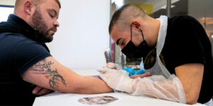Professionista che mostra come curare un tatuaggio