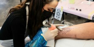 Tatuatrice che esegue tatuaggio ornamentale